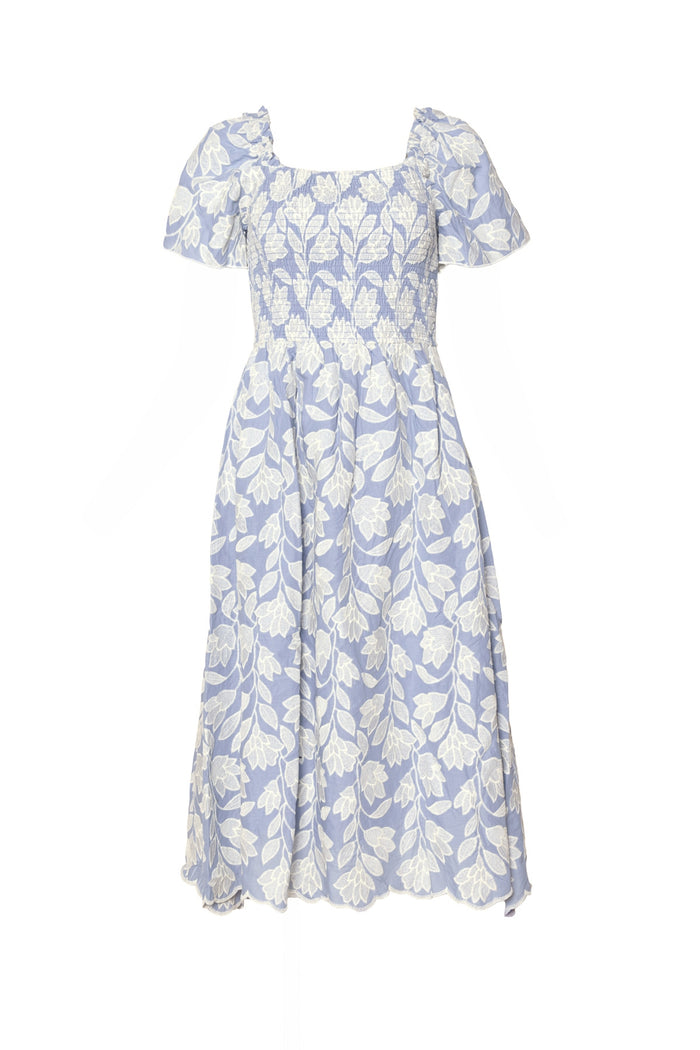 The Ophelia Dress in Mosaic Embroidery by Ivy City Co is a light blue midi summer dress with short puff sleeves, white floral leaf patterns, a smocked bodice, flared skirt, and a breezy maternity-friendly fit for any occasion.