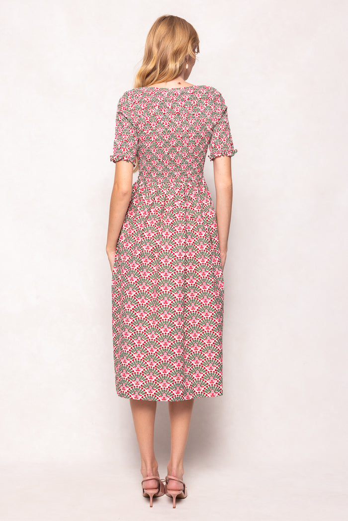 Woman wearing a pink and green patterned dress on a white background