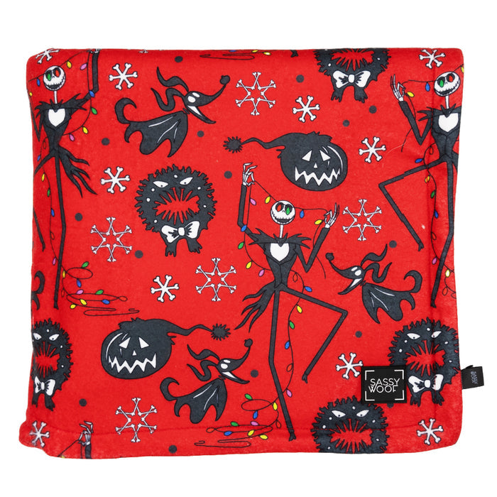 The Sassy Woof Pet Blanket - The Nightmare Before Christmas™ (Red) features black and white illustrations of Jack Skellington, Zero, wreaths, and snowflakes from the Christmas collection, with a stitched Sassy Woof label in one corner.