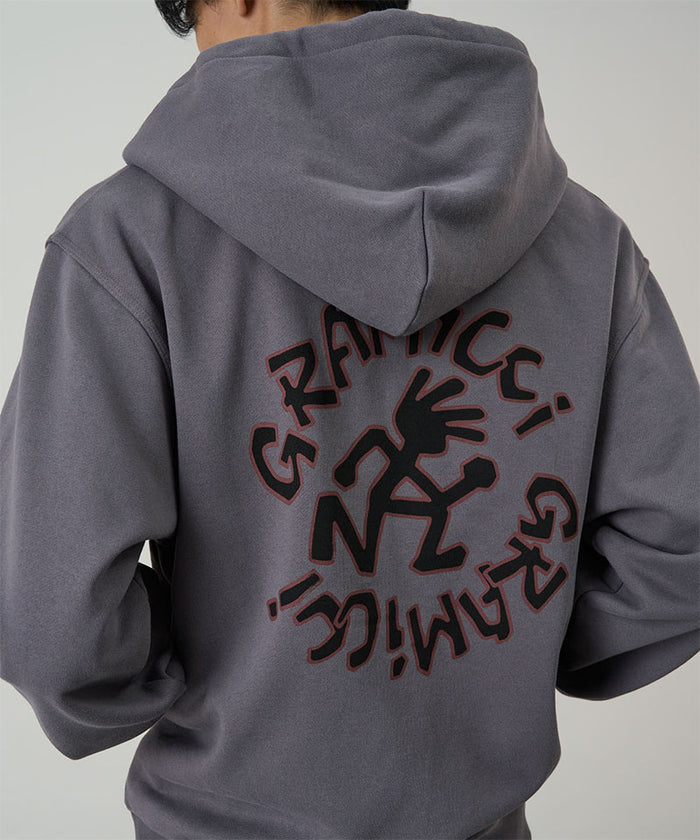Back view of a model wearing charcoal Gramicci Running Man Zip Hooded Sweatshirt on a light-tone background.