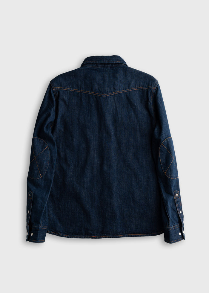 Dark denim shirt with elbow patches, back view. Features buttoned cuffs and contrast stitching on a plain white background.