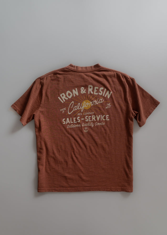 Brown T-shirt with "Iron & Resin California" and "Sales-Service" text, emphasizing outdoor quality goods.