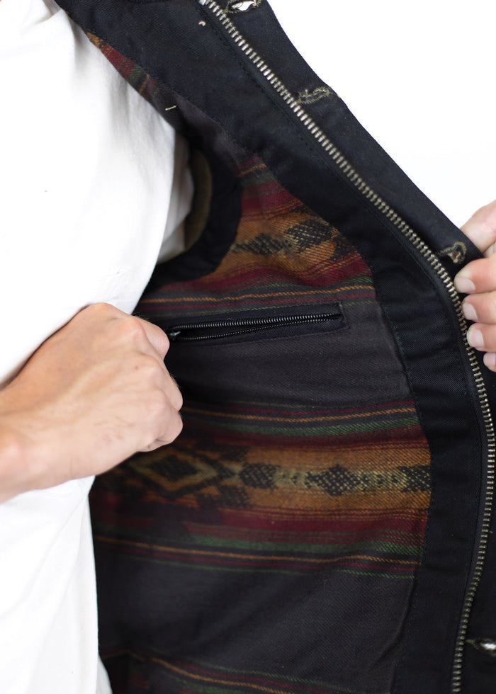 Person reveals jacket's colorful patterned lining with a zippered pocket, highlighting its stylish and functional design.