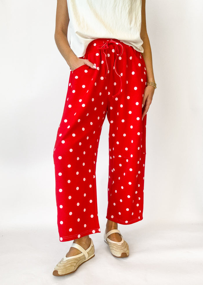 Person wearing red polka dot pants on a white background