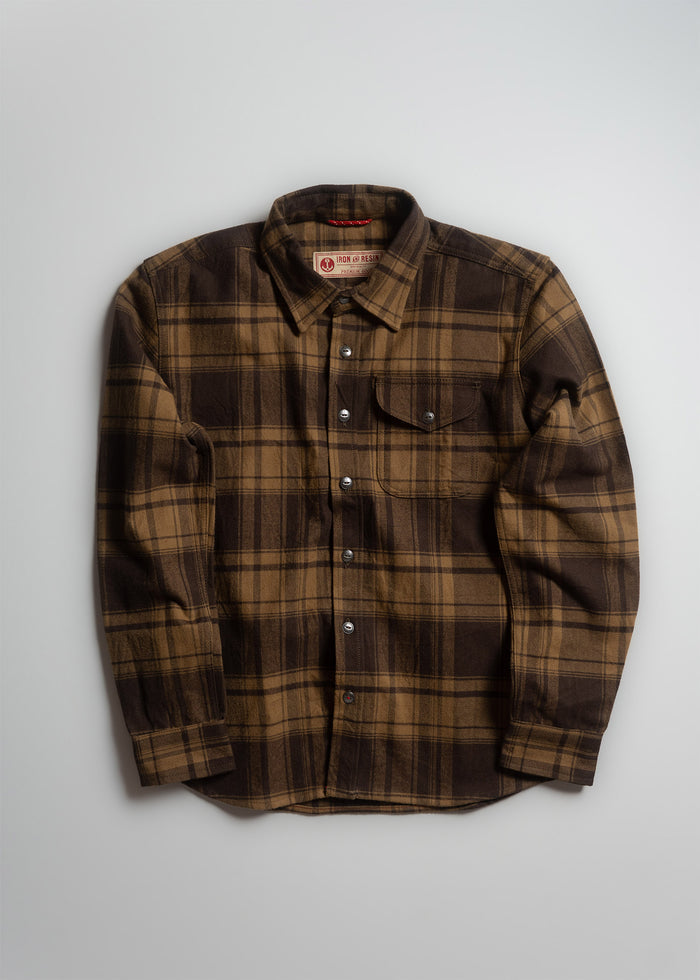 Brown plaid flannel shirt with buttoned front and single chest pocket, displayed on a light background.