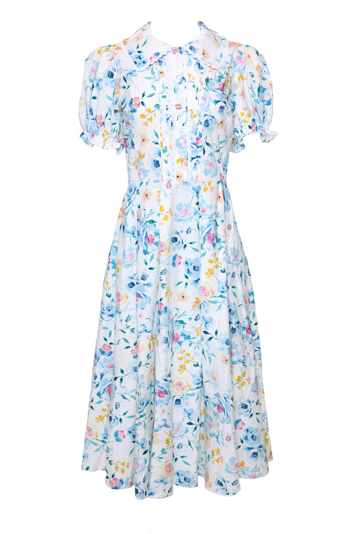 The Sophia Dress in Blue Bouquet by Ivy City Co is a vintage-style, nursing-friendly midi with blue, yellow, and pink florals on white. It features a fitted bodice, puffed sleeves, and a flared skirt for timeless charm and comfort.