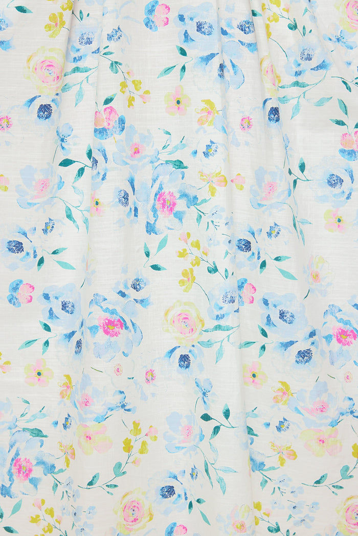 The Sophia Dress in Blue Bouquet by Ivy City Co features a watercolor floral pattern with blue, pink, and yellow flowers on light fabric. This airy midi dress has a soft, summery look perfect for warm days.