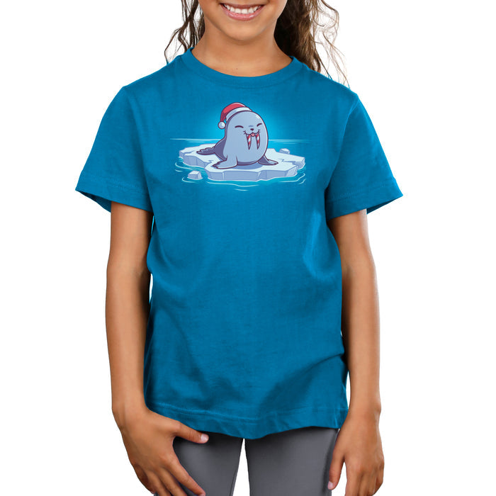 Premium Cotton T-shirt_TeeTurtle cobalt blue Sweet Tooth apparel featuring an illustration of a happy walrus sticking out it's tongue, wearing a Santa hat, and sitting on a floating ice. It's tusks are striped with red and white like candy canes.