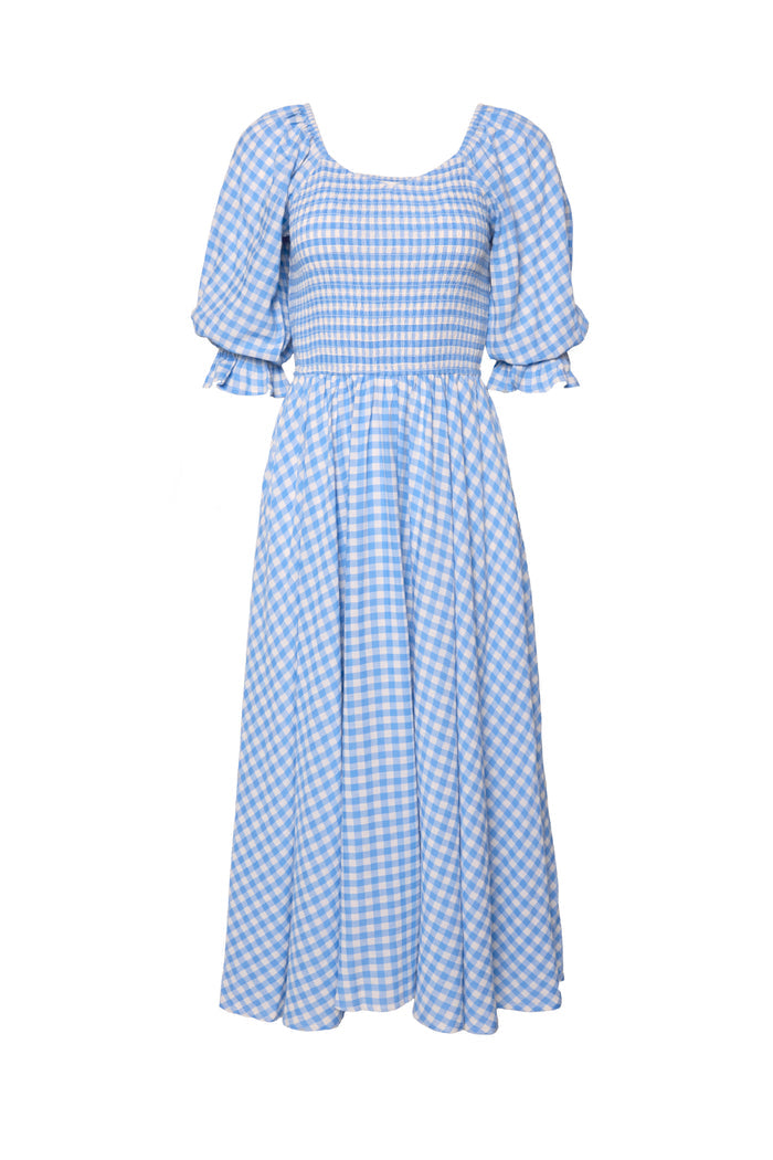 The Teagan Dress in Blue Gingham by Ivy City Co features a light blue and white gingham pattern, short puffed sleeves, a smocked bodice, and a flowing skirt—perfect as a nursing friendly dress for comfort and style.