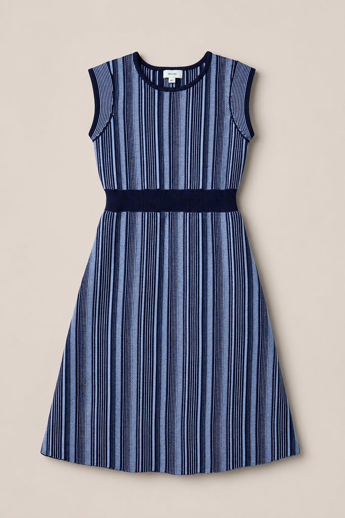The Ivy City Co Teen Laurel Dress in Midnight is a sleeveless, midi-length dress featuring vertical navy and light blue stripes, a fitted waistline, and a round neckline, displayed laid flat on a beige background.