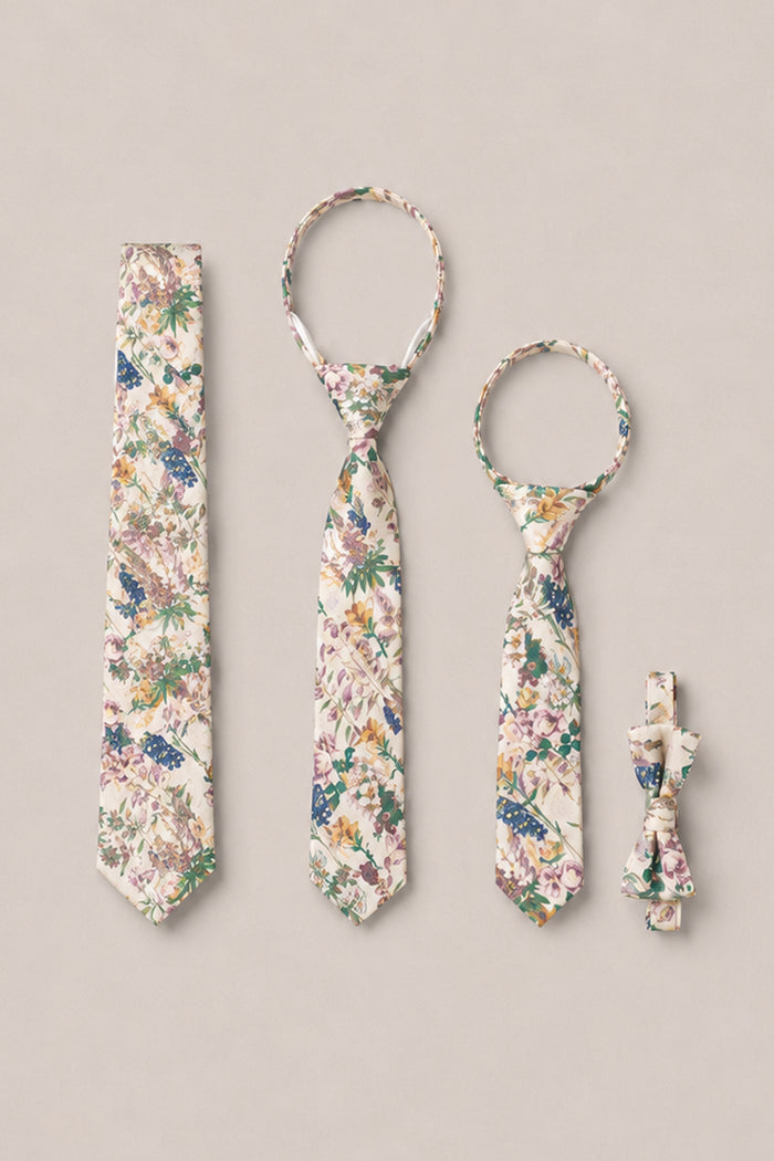 A set of four "Ties in Autumn Bouquet" accessories from Ivy City Co is displayed on a beige background: an adult tie, a child tie, a pet tie, and a matching pet bow tie. Each piece showcases the charming Autumn Bouquet pattern in coordinating cream, green, purple, and blue hues—ideal for bringing a touch of elegance to family photos.