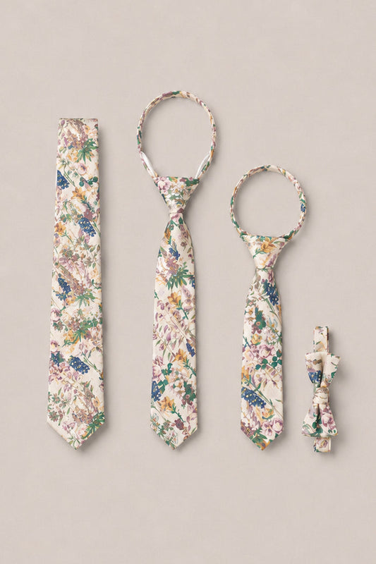 A set of four "Ties in Autumn Bouquet" accessories from Ivy City Co is displayed on a beige background: an adult tie, a child tie, a pet tie, and a matching pet bow tie. Each piece showcases the charming Autumn Bouquet pattern in coordinating cream, green, purple, and blue hues—ideal for bringing a touch of elegance to family photos.