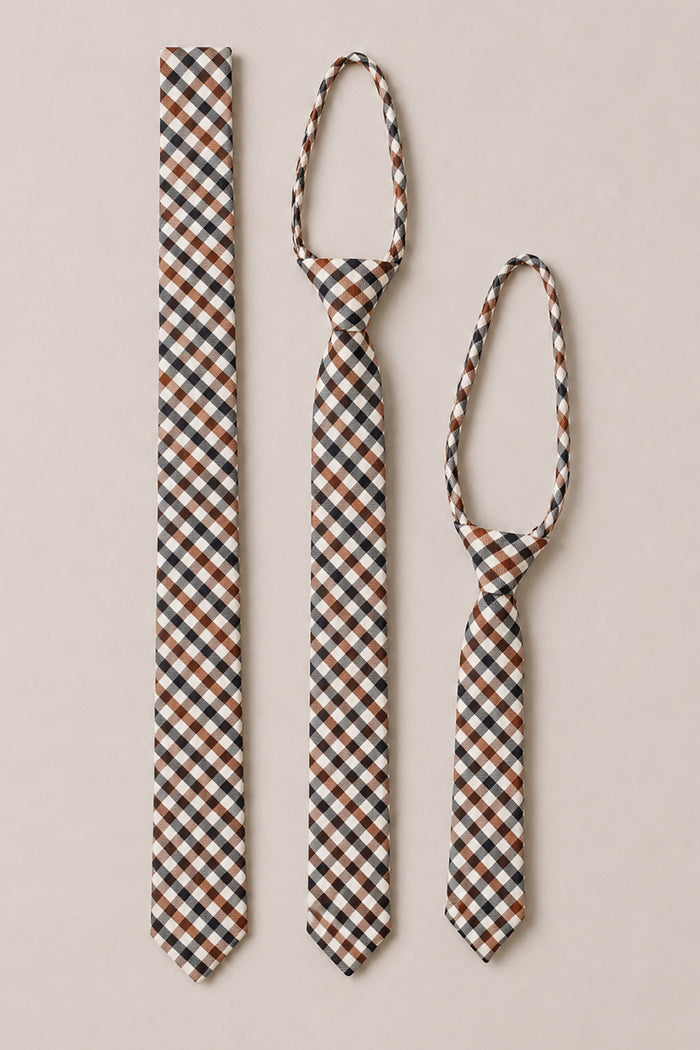 Three Ties in Chestnut Gingham by Ivy City Co, displayed in varying sizes side by side on a light beige background. These cotton ties feature a classic brown, black, and white checkered pattern—making them an ideal addition to any wedding accessory collection.