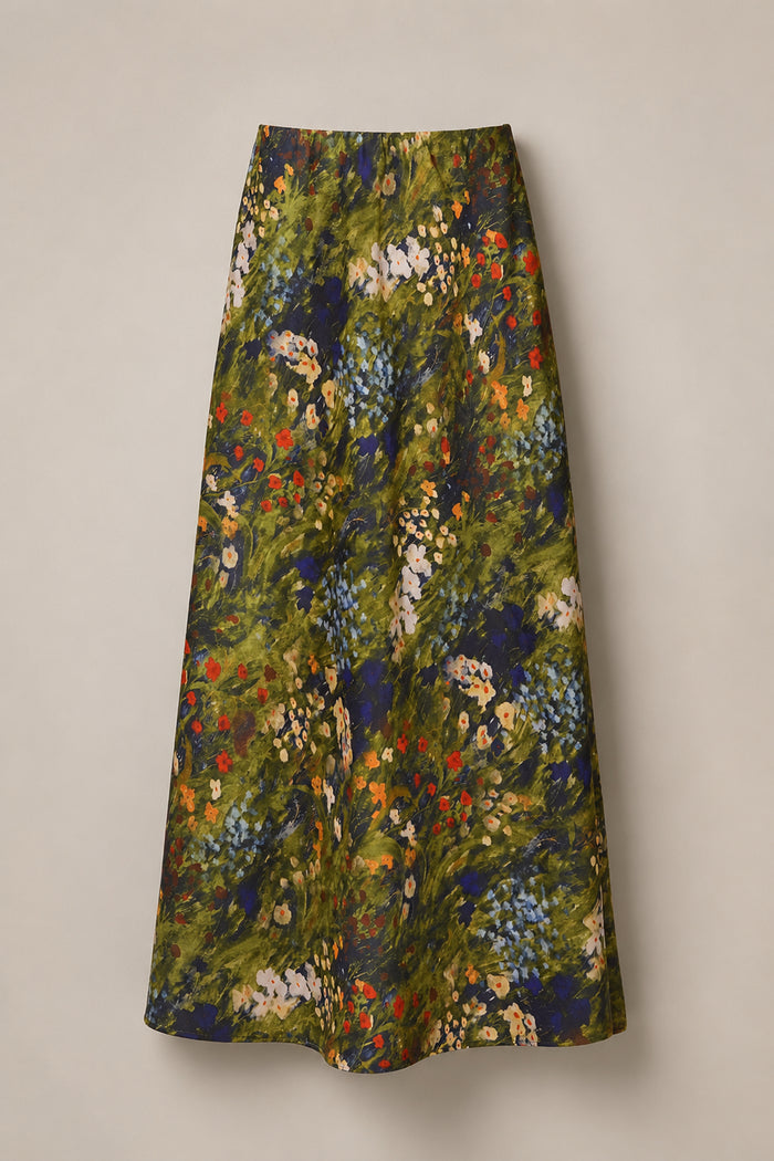 The Tiff Skirt in Impressionist Bloom by Ivy City Co is a long, high-waisted satin skirt with an A-line silhouette, showcasing a vibrant impressionist floral pattern in green, blue, red, and yellow hues on a beige background—making it the perfect statement piece for your next night out.