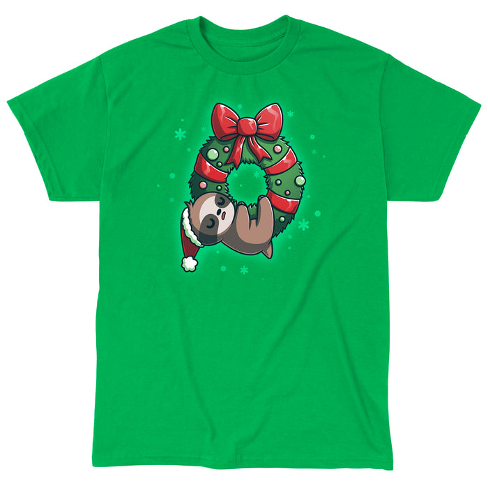 Classic Cotton T-shirt_TeeTurtle We Wish You a Lazy Christmas Irish green t-shirt featuring a cartoon sloth in a Santa hat, snoozing while hanging from a festive wreath adorned with red ribbons and ornaments.