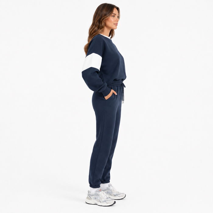 Women's navy drop shoulder sweatshirt set side view showing relaxed top and tapered joggers on white