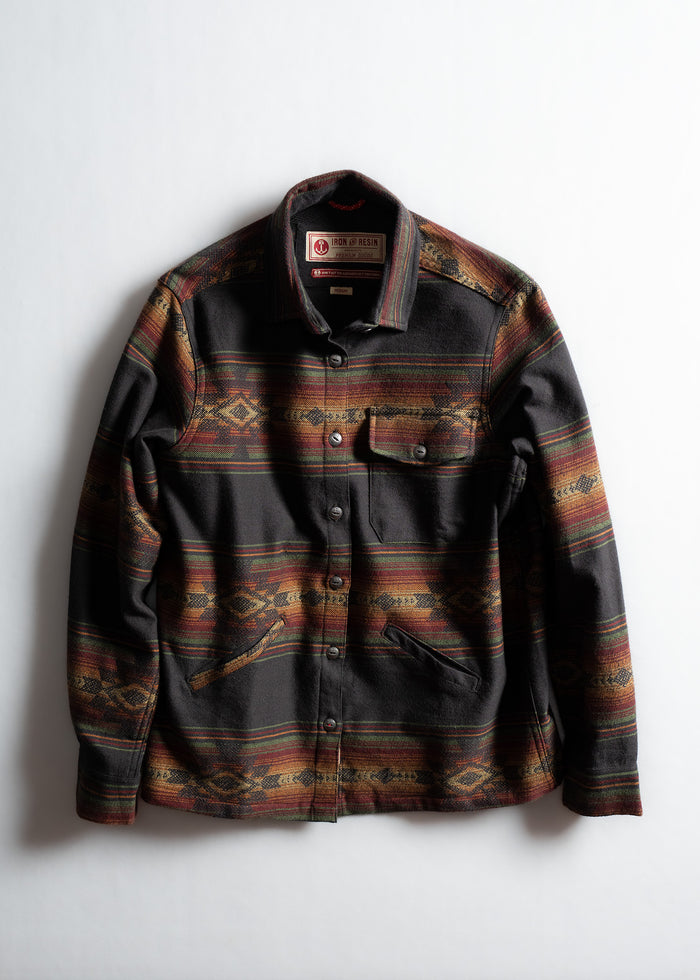 Patterned jacket with earthy tones and button closure, featuring a chest pocket and two side pockets, on a white background.