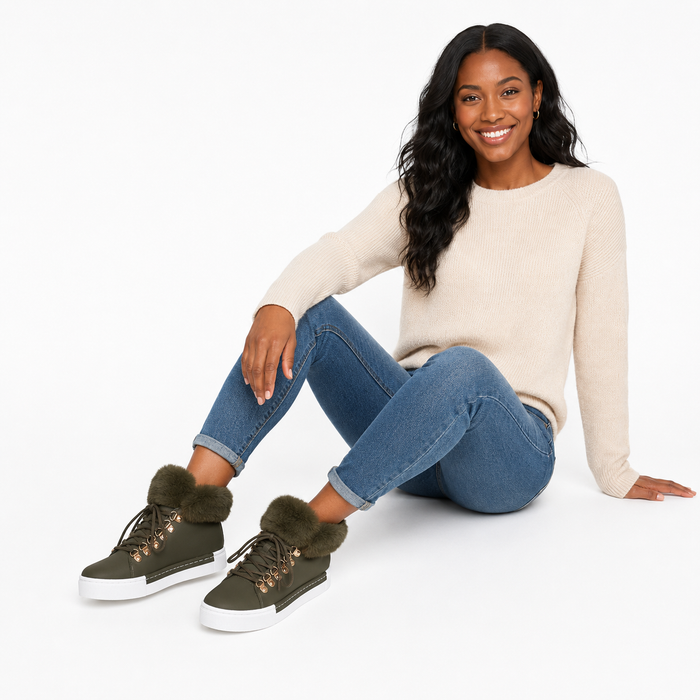 Women's green lace-up ankle boots with fuzzy faux fur collar in a seated lifestyle pose