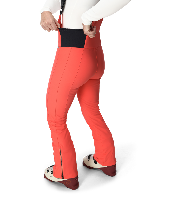 Person wearing bright orange ski pants on a white background