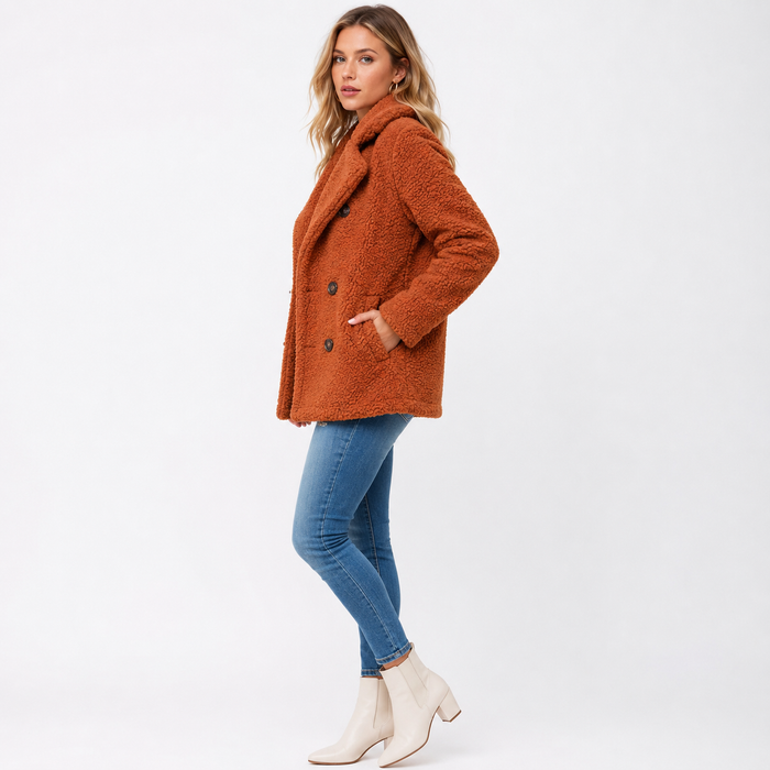 Women's rust teddy winter coat side view on white background