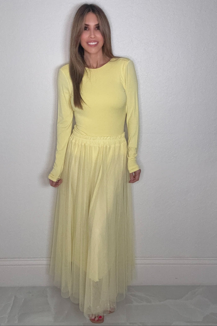 Buttercup yellow long sleeve top with a low open back detail styled for a soft feminine boutique look.