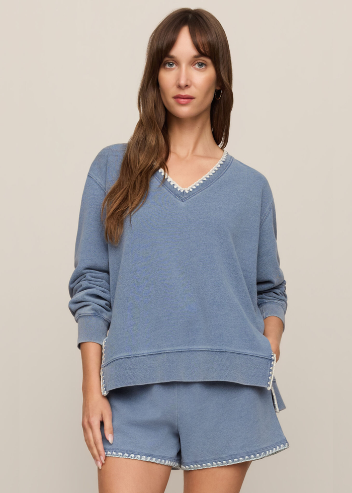 Woman wearing a blue knit denim sweatshirt with whipstitch trim and matching shorts